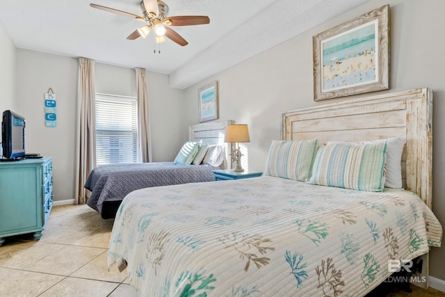 bedroom featuring a textured ceiling, ceiling fan, and light tile patterned floors