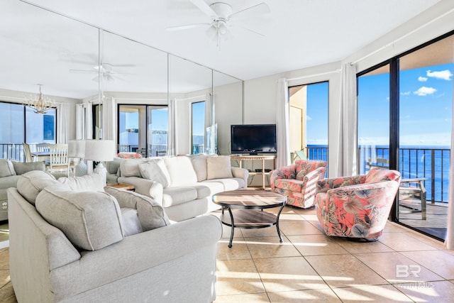 tiled living room with ceiling fan with notable chandelier