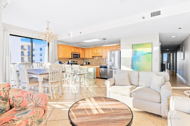 living room featuring light tile patterned floors, sink, and an inviting chandelier