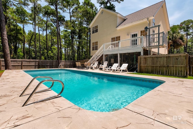 view of swimming pool featuring a patio and a deck