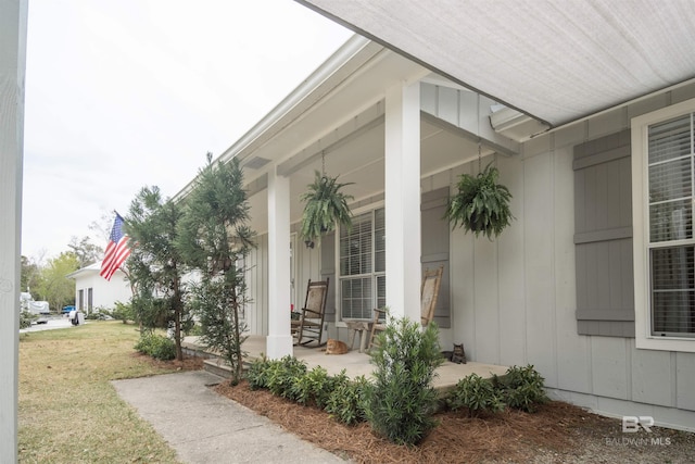 view of side of home featuring a porch and a lawn