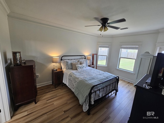 bedroom with ornamental molding, visible vents, light wood-style flooring, and baseboards