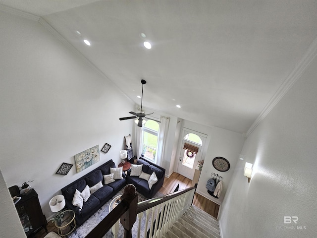 living area with lofted ceiling, recessed lighting, ornamental molding, wood finished floors, and baseboards