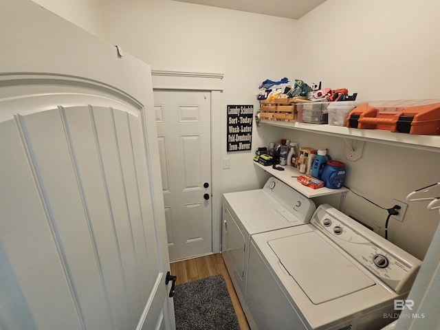 laundry room featuring laundry area, washing machine and clothes dryer, and wood finished floors