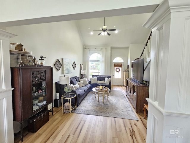 living room with light wood-style flooring, stairs, vaulted ceiling, and a ceiling fan