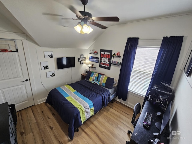 bedroom featuring lofted ceiling, ceiling fan, baseboards, and wood finished floors