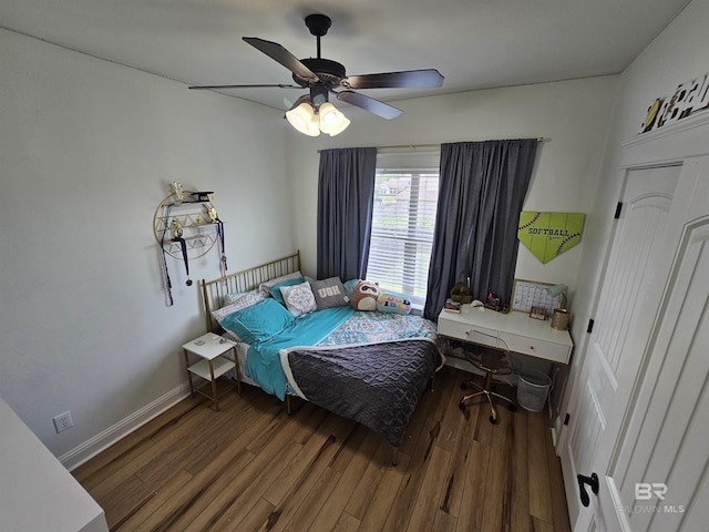 bedroom featuring a ceiling fan, baseboards, and wood finished floors