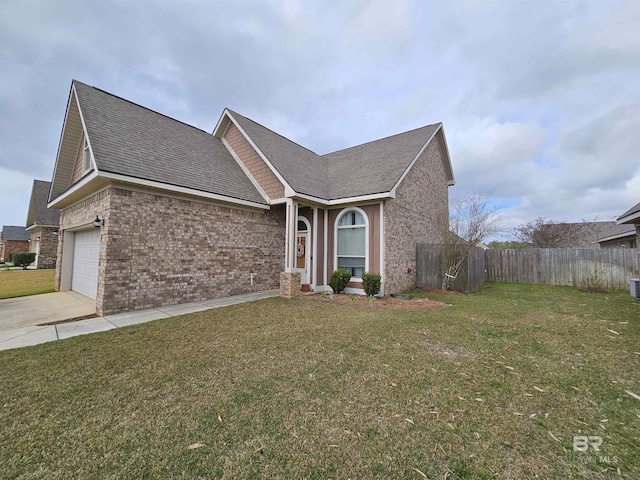 view of front of home featuring an attached garage, brick siding, fence, driveway, and a front lawn