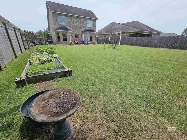 view of yard with a fenced backyard and a garden