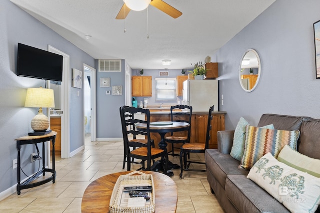 tiled living room featuring ceiling fan