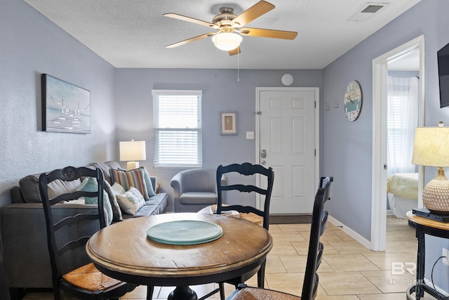 dining room with a textured ceiling and ceiling fan