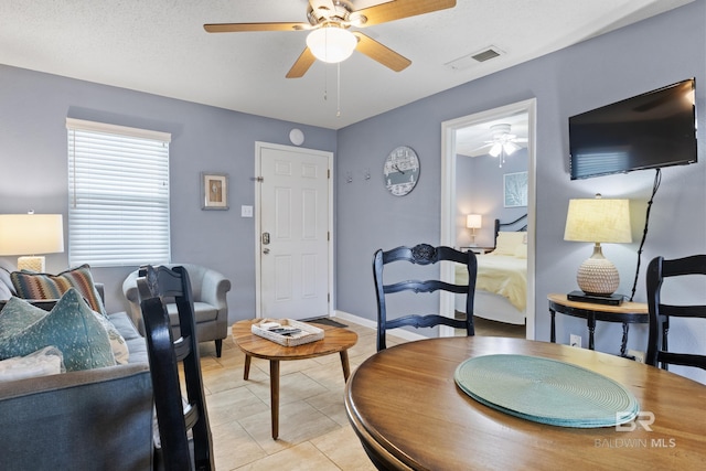 interior space featuring light tile patterned floors and ceiling fan