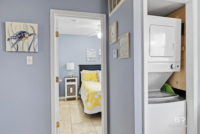 interior space featuring stacked washer / drying machine and light tile patterned floors