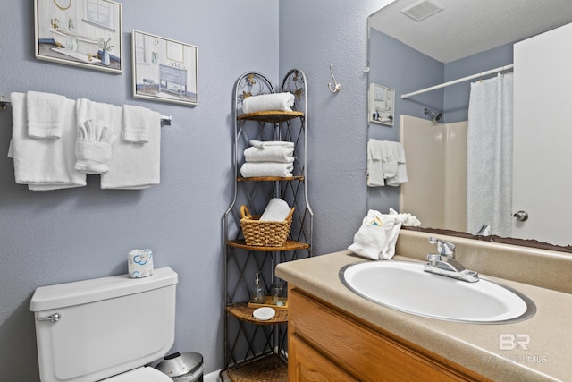 bathroom featuring vanity, curtained shower, and toilet