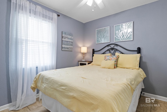 bedroom with multiple windows, light tile patterned floors, and ceiling fan