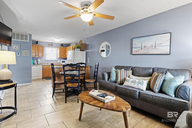 tiled living room featuring sink and ceiling fan