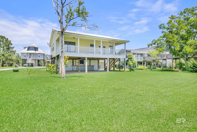 rear view of house featuring a porch and a yard