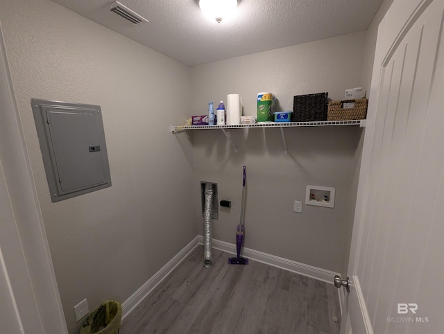 laundry area featuring hookup for a washing machine, visible vents, wood finished floors, laundry area, and electric panel