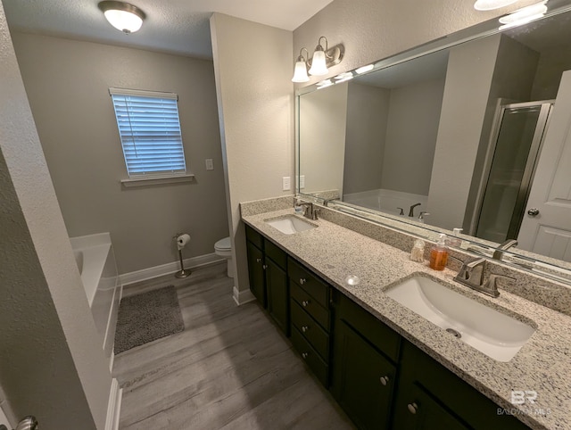 bathroom featuring a garden tub, wood finished floors, and a sink