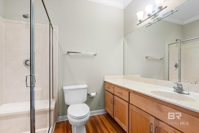 bathroom with an enclosed shower, ornamental molding, vanity, wood-type flooring, and toilet