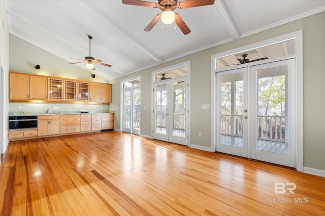 kitchen with black oven, light hardwood / wood-style floors, light brown cabinetry, and french doors