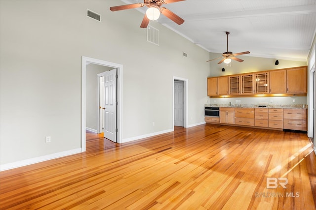 kitchen featuring light stone counters, high vaulted ceiling, light hardwood / wood-style floors, and ceiling fan