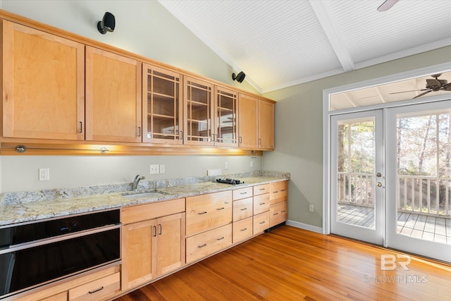 kitchen with light stone countertops, light brown cabinetry, ceiling fan, sink, and light hardwood / wood-style flooring