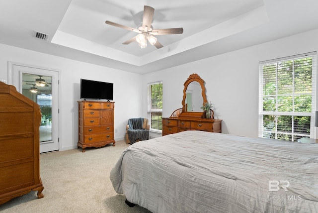 22091 Pecan Loop, Silverhill, AL 36576 - carpeted bedroom with a raised ceiling, multiple windows, and ceiling fan