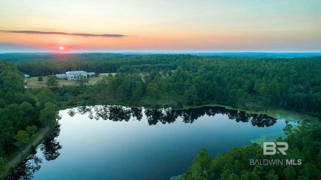 aerial view at dusk featuring a water view