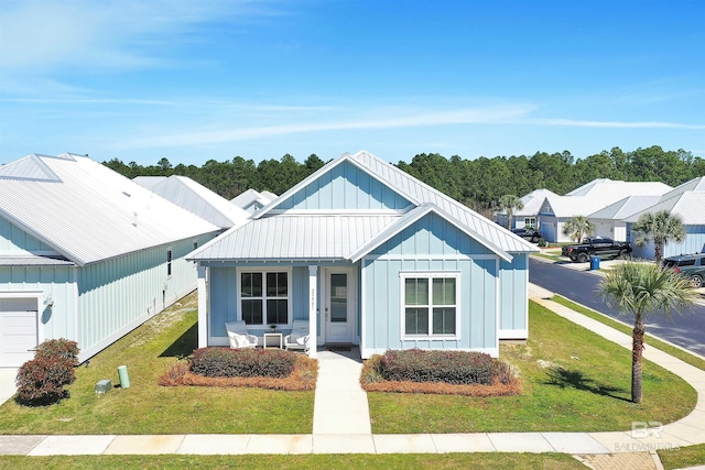 23901 Cypress Xing, Orange Beach, AL 36561 - modern farmhouse style home featuring board and batten siding, an attached garage, and a front lawn