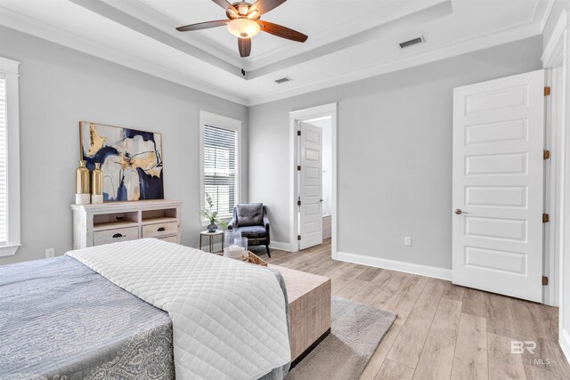 23901 Cypress Xing, Orange Beach, AL 36561 - bedroom featuring visible vents, crown molding, baseboards, a raised ceiling, and light wood-type flooring