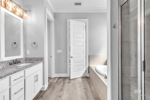 23901 Cypress Xing, Orange Beach, AL 36561 - full bathroom with vanity, a shower stall, a garden tub, visible vents, and wood finished floors
