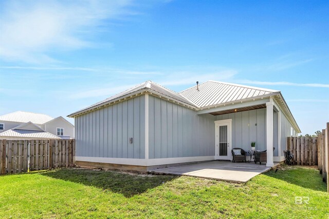 23901 Cypress Xing, Orange Beach, AL 36561 - back of property featuring a patio, a lawn, and a fenced backyard