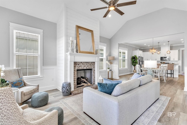 23901 Cypress Xing, Orange Beach, AL 36561 - living area with ceiling fan with notable chandelier, light wood-type flooring, lofted ceiling, and wainscoting