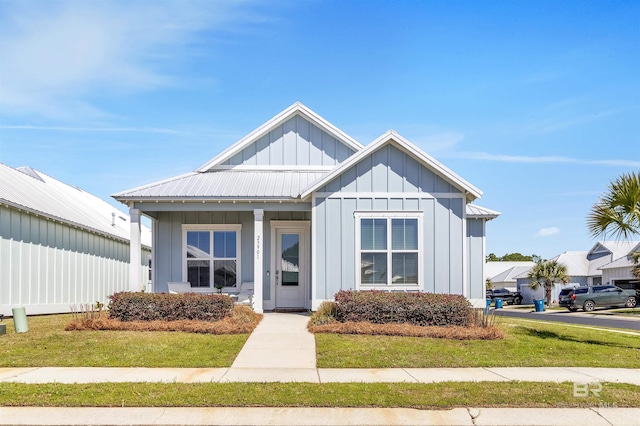 23901 Cypress Xing, Orange Beach, AL 36561 - view of front of property with metal roof, a front lawn, and board and batten siding