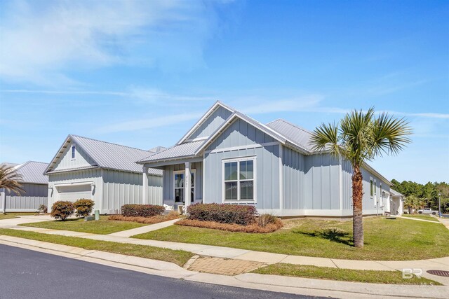 23901 Cypress Xing, Orange Beach, AL 36561 - modern farmhouse style home with an attached garage, a front lawn, board and batten siding, and concrete driveway
