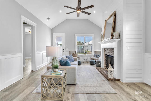 23901 Cypress Xing, Orange Beach, AL 36561 - living area featuring light wood-style flooring, vaulted ceiling, a fireplace, and ceiling fan