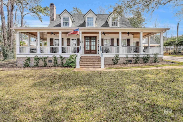 farmhouse with a porch, a front yard, and ceiling fan