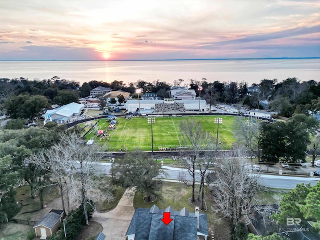 aerial view at dusk featuring a water view