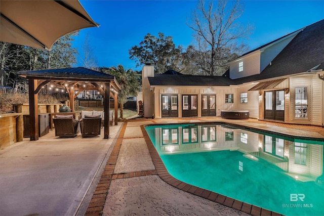 outdoor pool featuring french doors, a hot tub, a gazebo, a patio area, and an outdoor living space