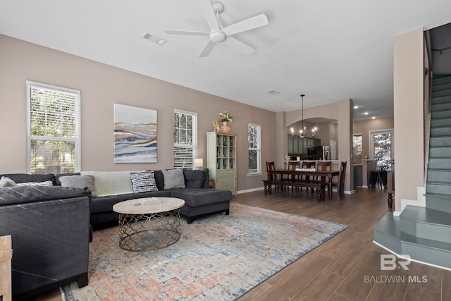 living room featuring ceiling fan with notable chandelier and wood-type flooring