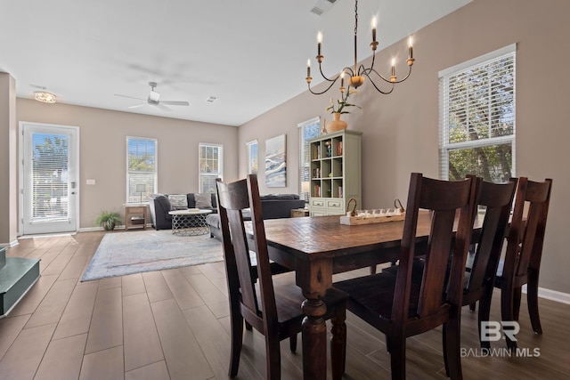 dining space with hardwood / wood-style floors, ceiling fan with notable chandelier, and a healthy amount of sunlight