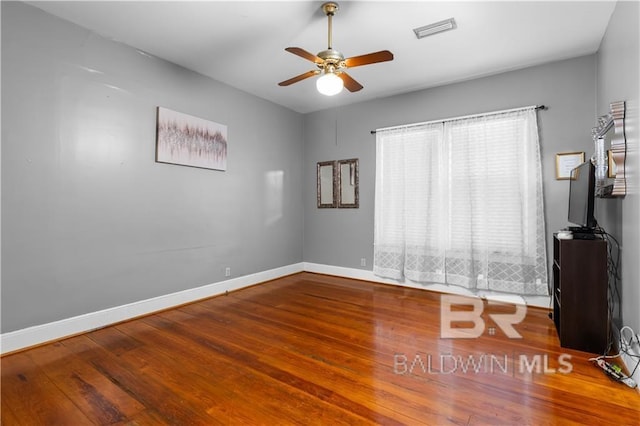 spare room with hardwood / wood-style floors and ceiling fan