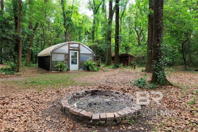 view of yard with an outdoor structure and a fire pit