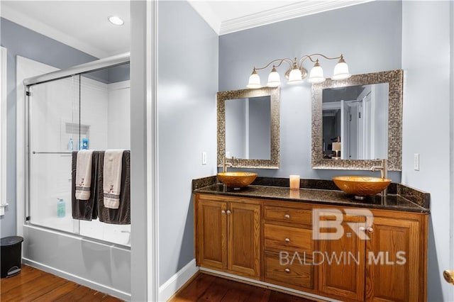 bathroom with hardwood / wood-style floors, crown molding, dual vanity, and shower / bath combination with glass door