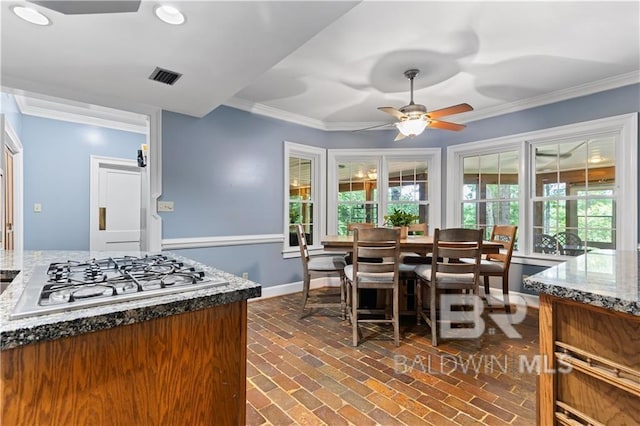 dining space with ceiling fan and crown molding