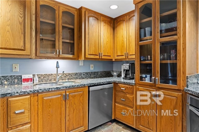 kitchen with dark stone counters, stainless steel appliances, and sink