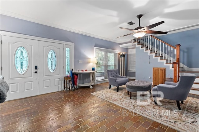 foyer with ornamental molding and ceiling fan