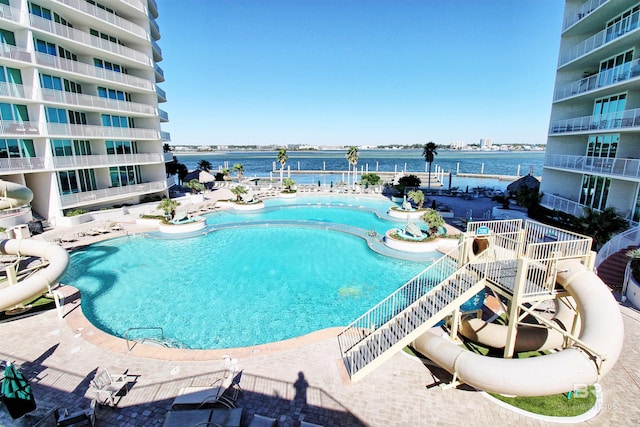 view of pool with a patio area and a water view