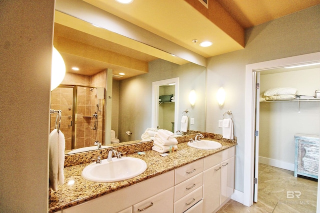 bathroom featuring tile patterned flooring, vanity, toilet, and walk in shower